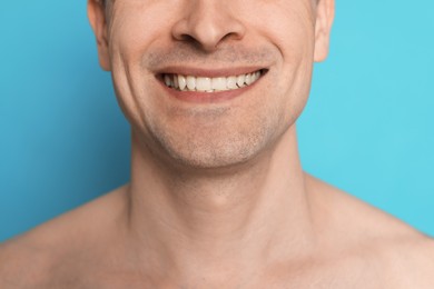 Photo of Smiling man after shaving on light blue background, closeup