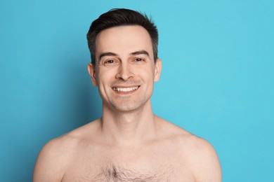 Photo of Smiling man after shaving on light blue background