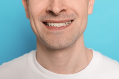 Photo of Smiling man after shaving on light blue background, closeup