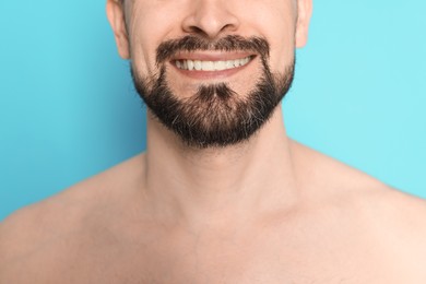Photo of Smiling man before shaving on light blue background, closeup