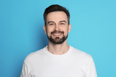 Photo of Smiling man before shaving on light blue background