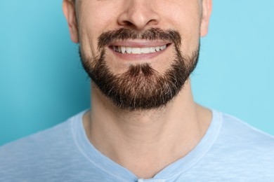 Photo of Smiling man before shaving on light blue background, closeup