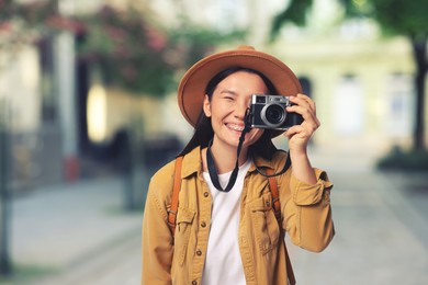 Image of Happy tourist taking photo on city street