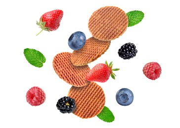Image of Tasty Dutch waffles, fresh berries and mint flying on white background