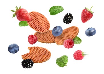Image of Tasty Dutch waffles, fresh berries and mint flying on white background