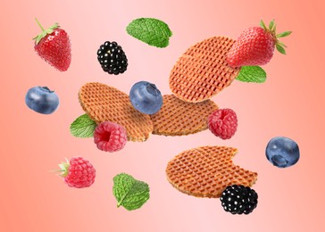 Image of Tasty Dutch waffles, fresh berries and mint flying on pink gradient background