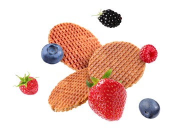 Image of Tasty Dutch waffles and fresh berries flying on white background