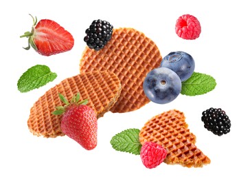 Image of Tasty Dutch waffles, fresh berries and mint flying on white background