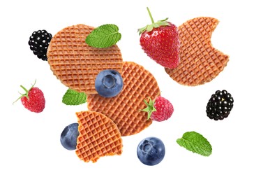 Image of Tasty Dutch waffles, fresh berries and mint flying on white background