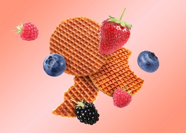 Image of Tasty Dutch waffles and fresh berries flying on pink gradient background