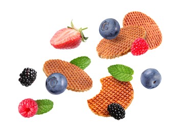 Image of Tasty Dutch waffles, fresh berries and mint flying on white background