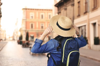 Image of Tourist with backpack on city street, back view. Space for text