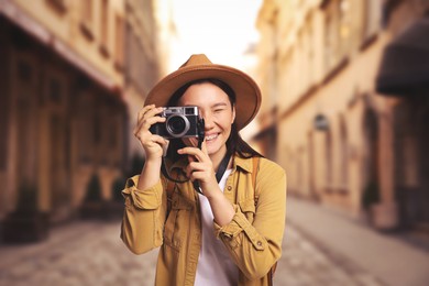 Image of Happy tourist taking photo on city street
