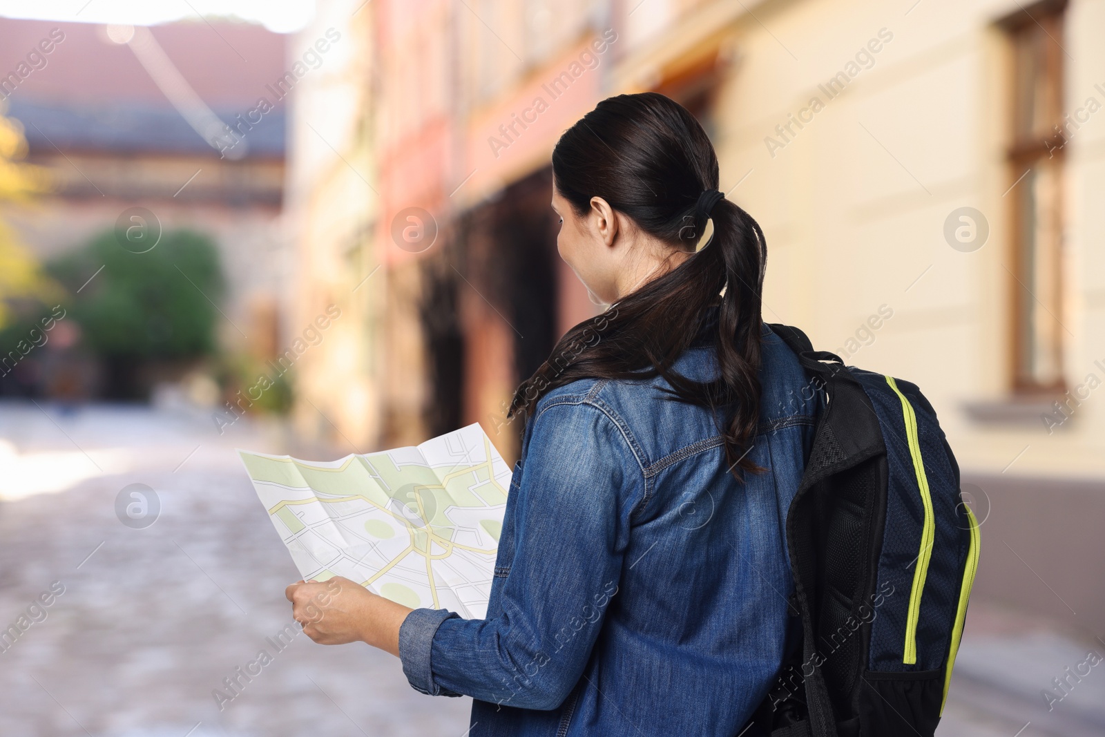 Tourist with map and backpack on city street Image of Tourist with map and backpack on city street