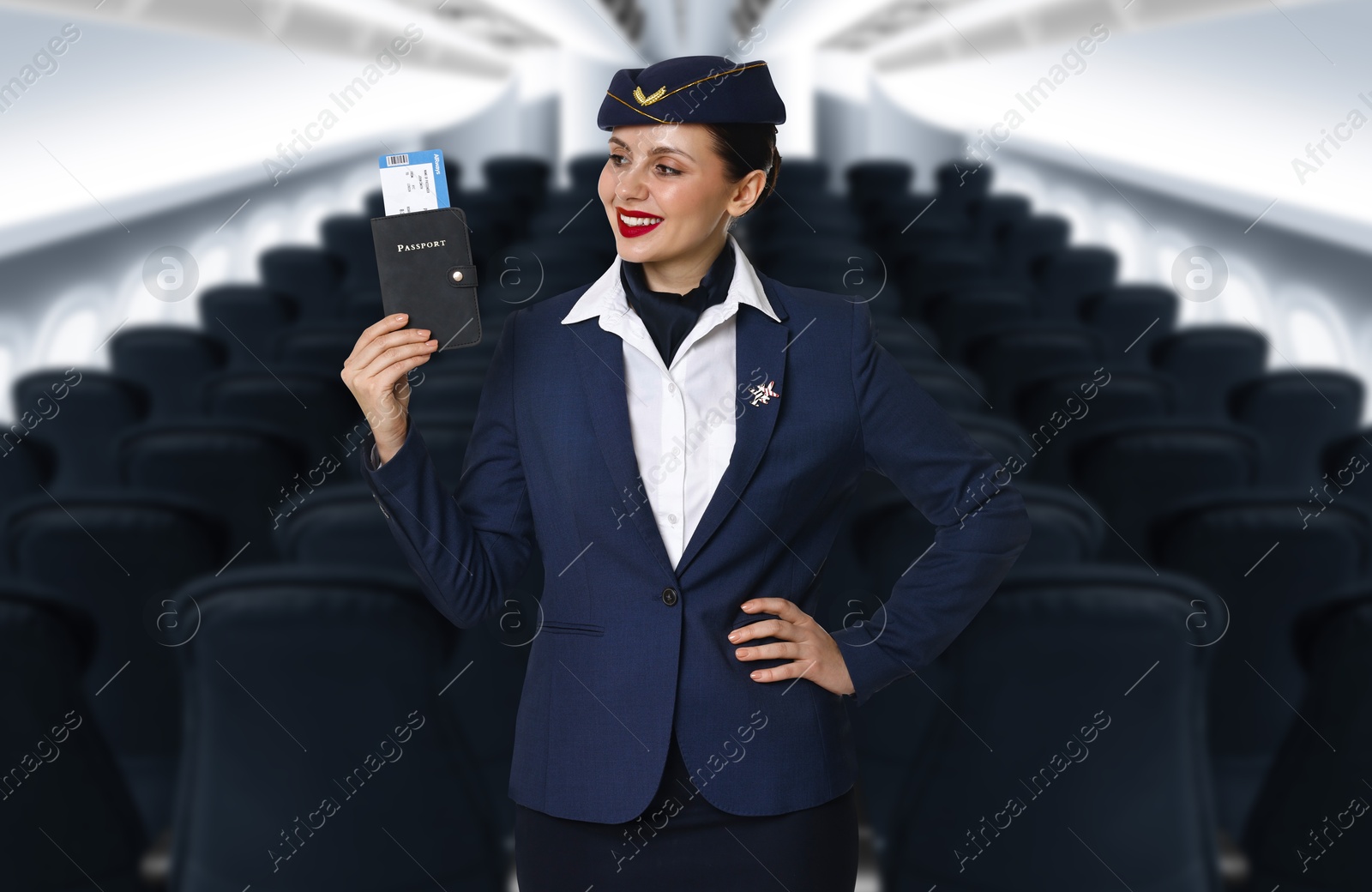 Smiling stewardess holding passport with flight ticket in airplane cabin Image of Smiling stewardess holding passport with flight ticket in airplane cabin