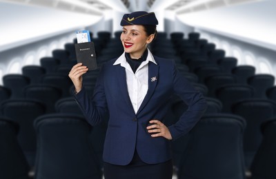 Image of Smiling stewardess holding passport with flight ticket in airplane cabin