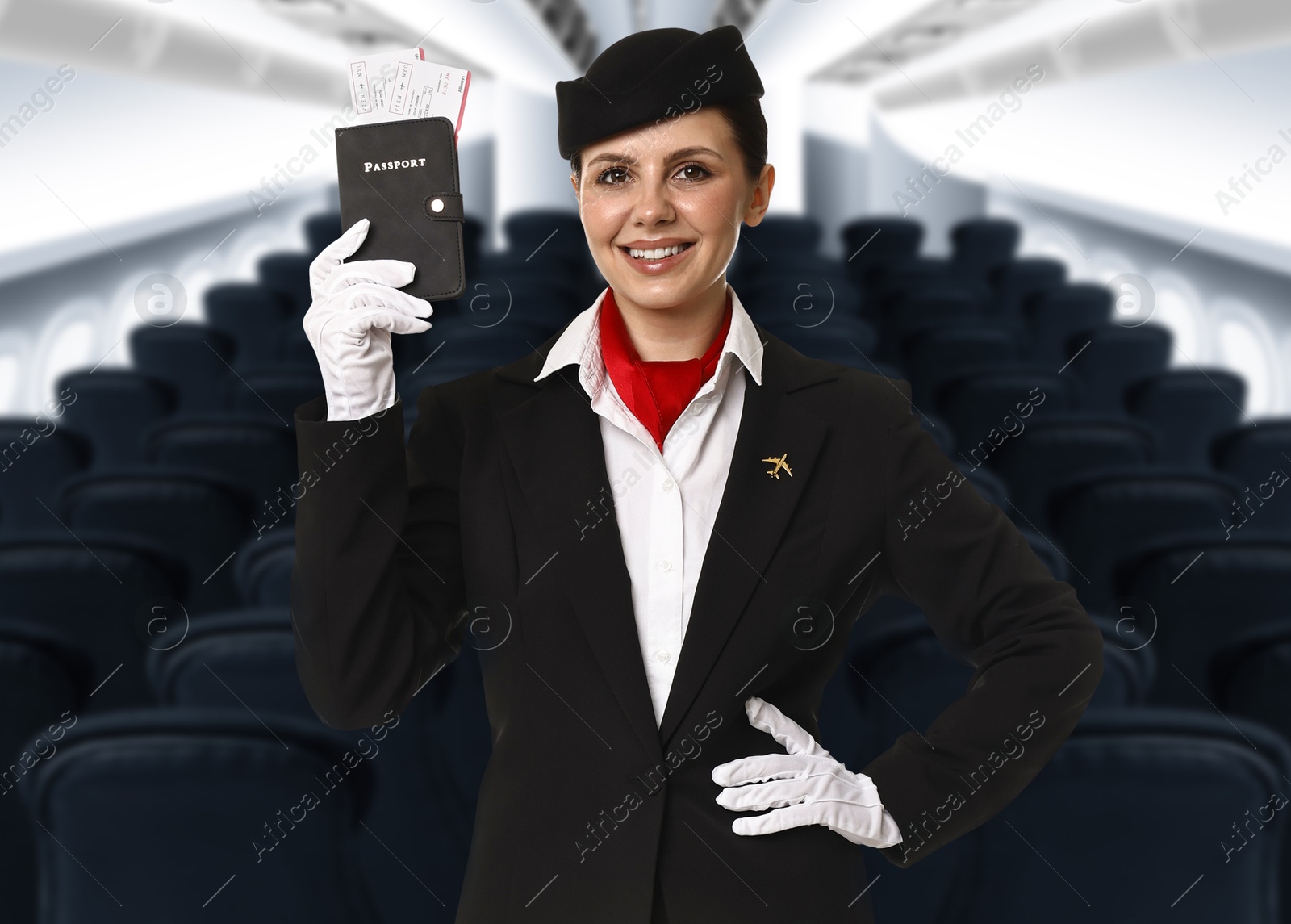 Smiling stewardess holding passport with flight tickets in airplane cabin Image of Smiling stewardess holding passport with flight tickets in airplane cabin