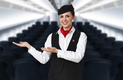 Image of Smiling stewardess welcoming passengers in airplane cabin