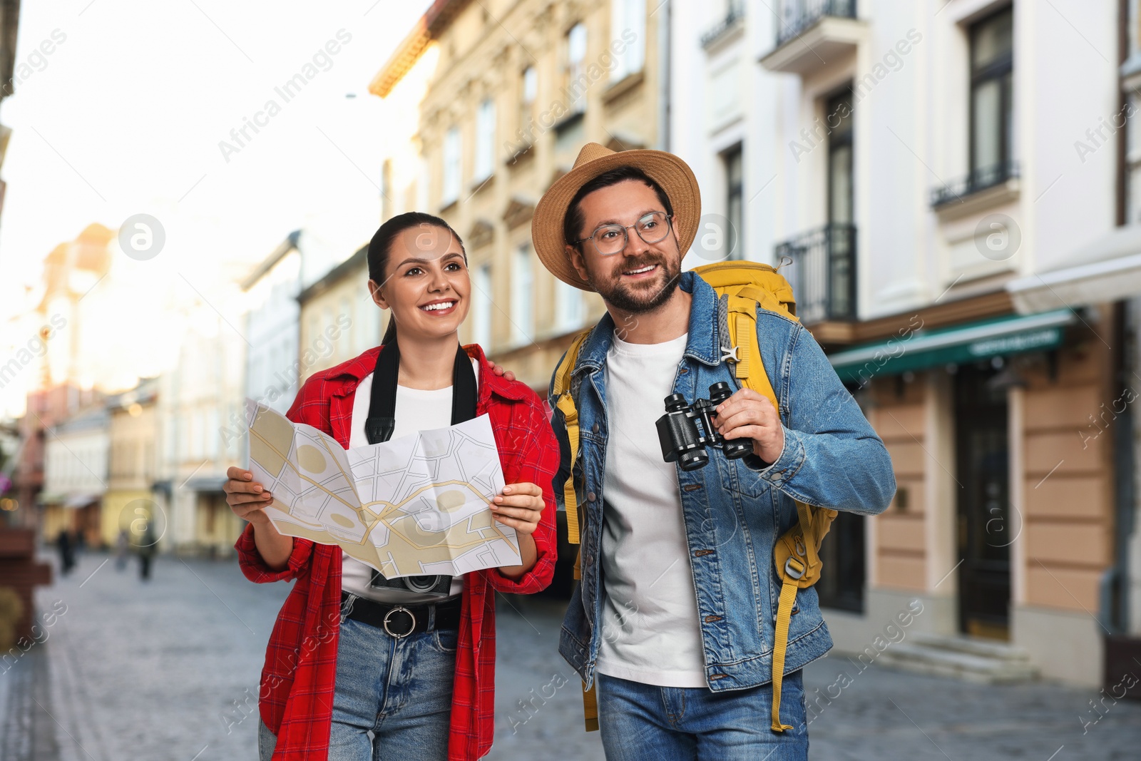Happy tourists with backpack, map and binoculars on city street Image of Happy tourists with backpack, map and binoculars on city street