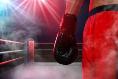 Image of Boxer surrounded by smoke in ring, closeup. Sporting event