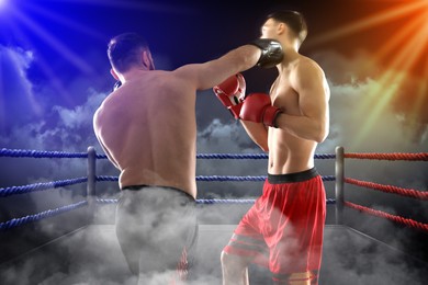 Image of Boxers surrounded by smoke fighting in ring. Sporting event