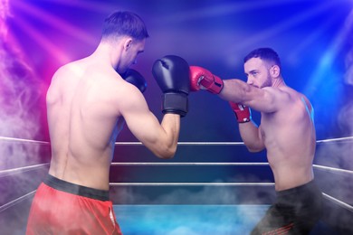 Image of Boxers surrounded by smoke fighting in ring. Sporting event
