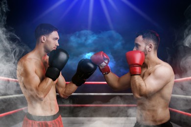 Image of Boxers surrounded by smoke fighting in ring. Sporting event
