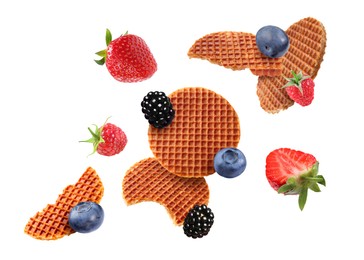 Image of Tasty Dutch waffles and fresh berries flying on white background