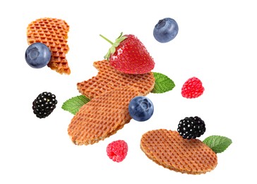 Image of Tasty Dutch waffles, fresh berries and mint flying on white background