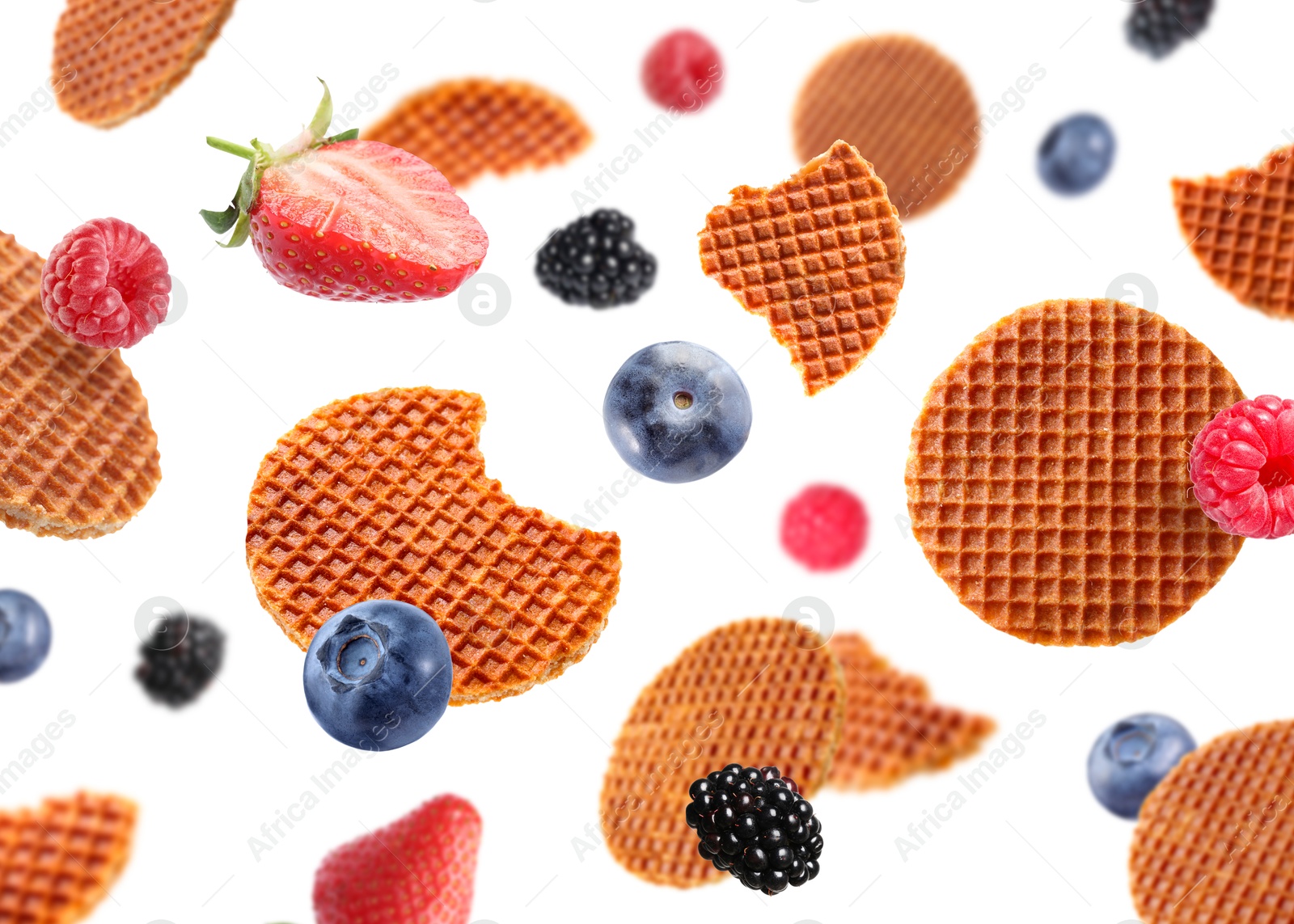 Image of Tasty Dutch waffles and fresh berries flying on white background