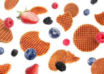 Image of Tasty Dutch waffles and fresh berries flying on white background
