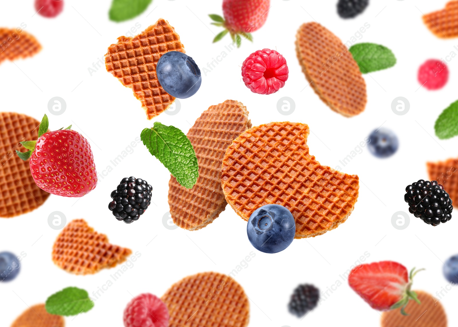 Tasty Dutch waffles and fresh berries flying on white background Image of Tasty Dutch waffles and fresh berries flying on white background