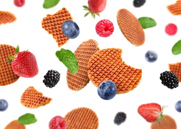 Image of Tasty Dutch waffles and fresh berries flying on white background