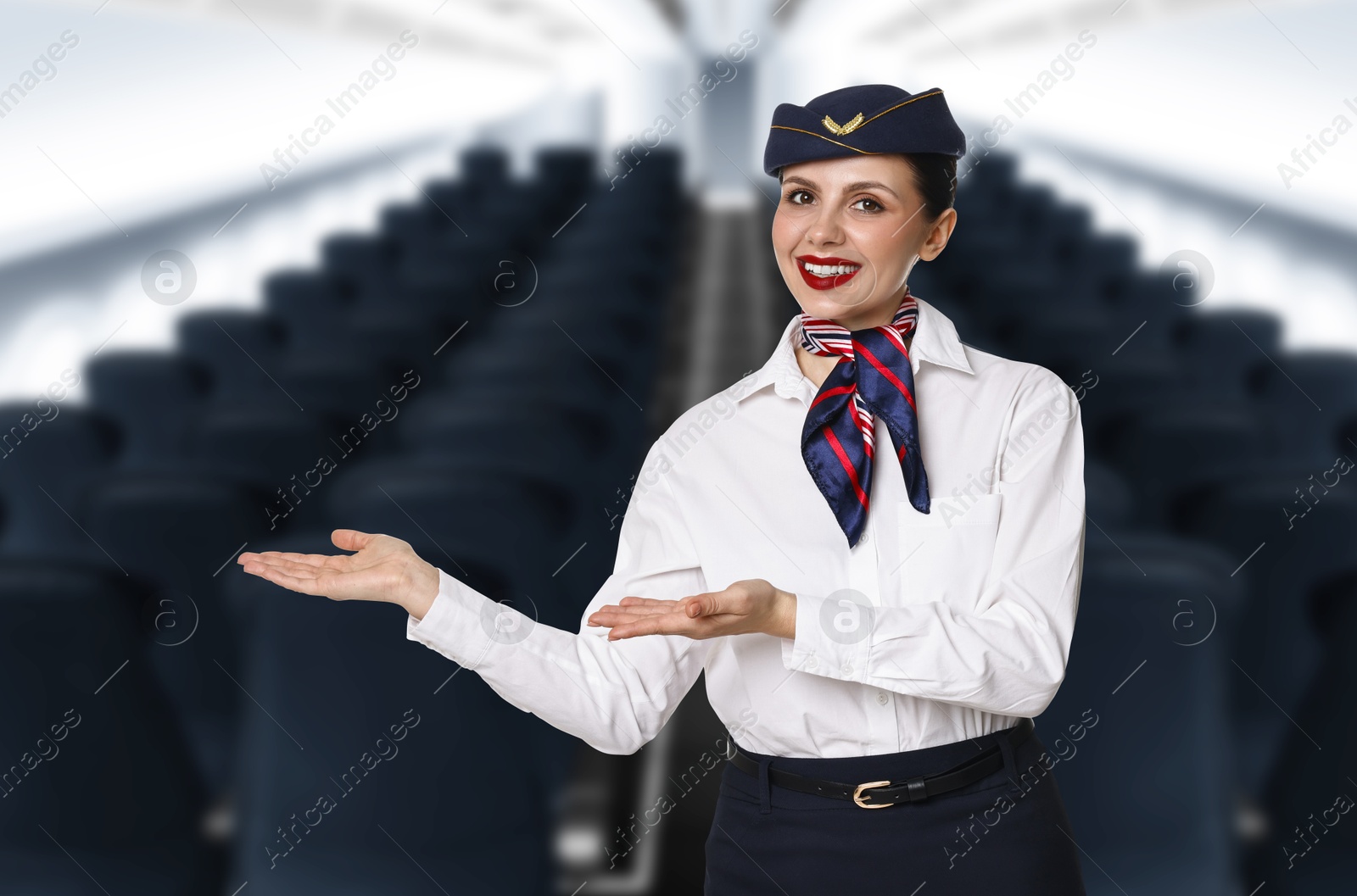 Smiling stewardess welcoming passengers in airplane cabin Image of Smiling stewardess welcoming passengers in airplane cabin
