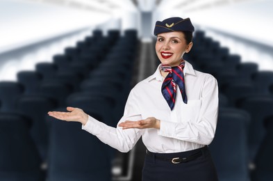 Image of Smiling stewardess welcoming passengers in airplane cabin
