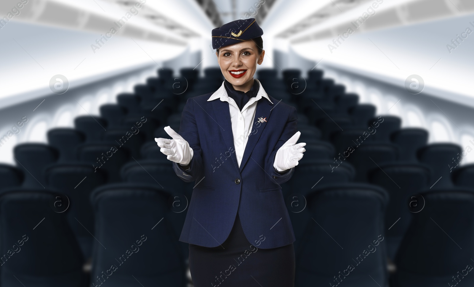 Smiling stewardess demonstrating safety instruction in airplane cabin Image of Smiling stewardess demonstrating safety instruction in airplane cabin