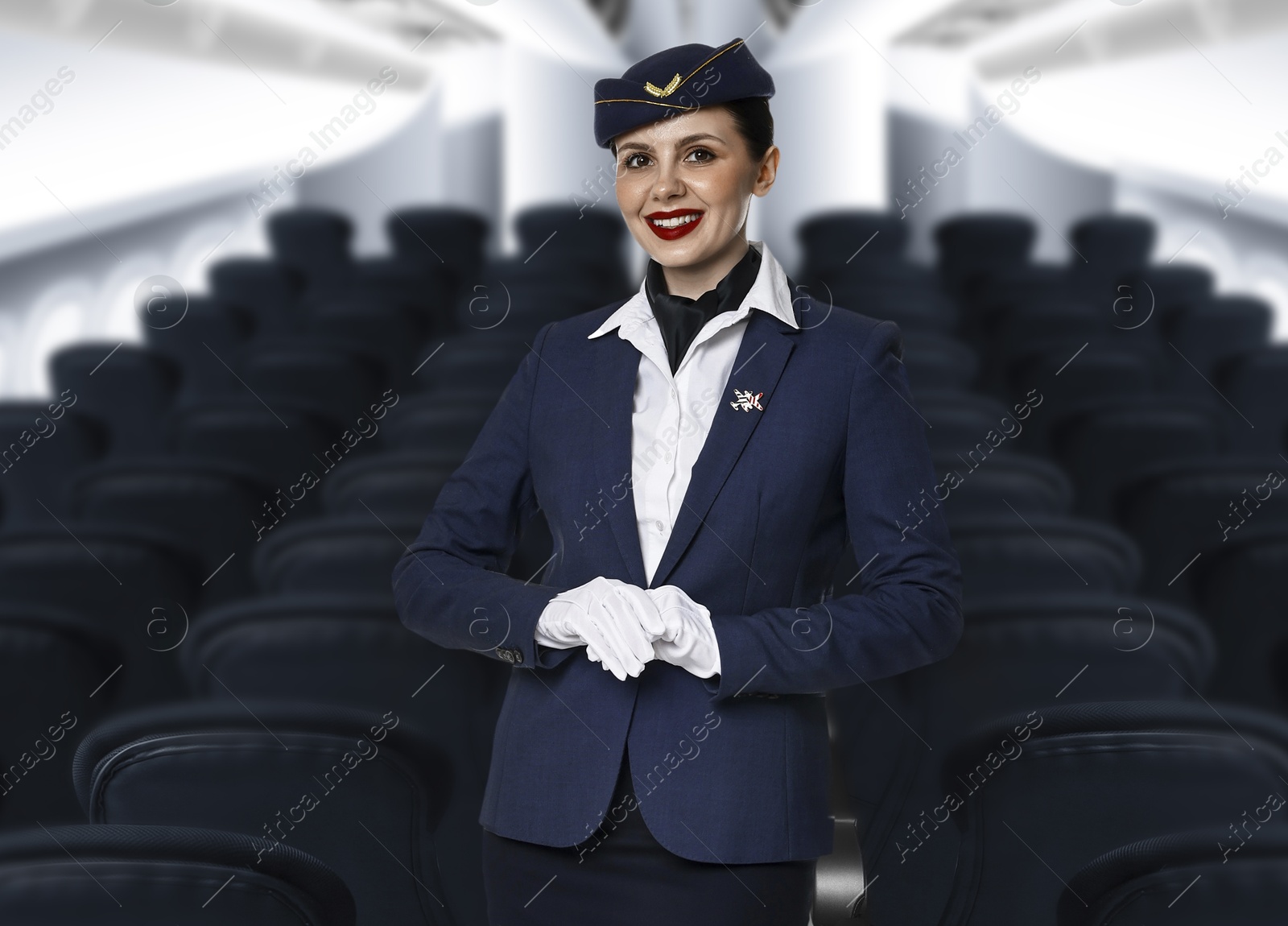 Smiling stewardess in airplane cabin with comfortable seats Image of Smiling stewardess in airplane cabin with comfortable seats