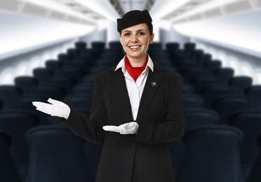 Image of Smiling stewardess welcoming passengers in airplane cabin