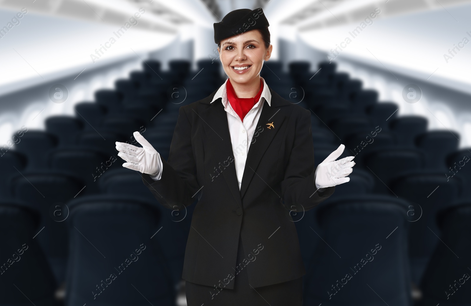Smiling stewardess demonstrating safety instruction in airplane cabin Image of Smiling stewardess demonstrating safety instruction in airplane cabin