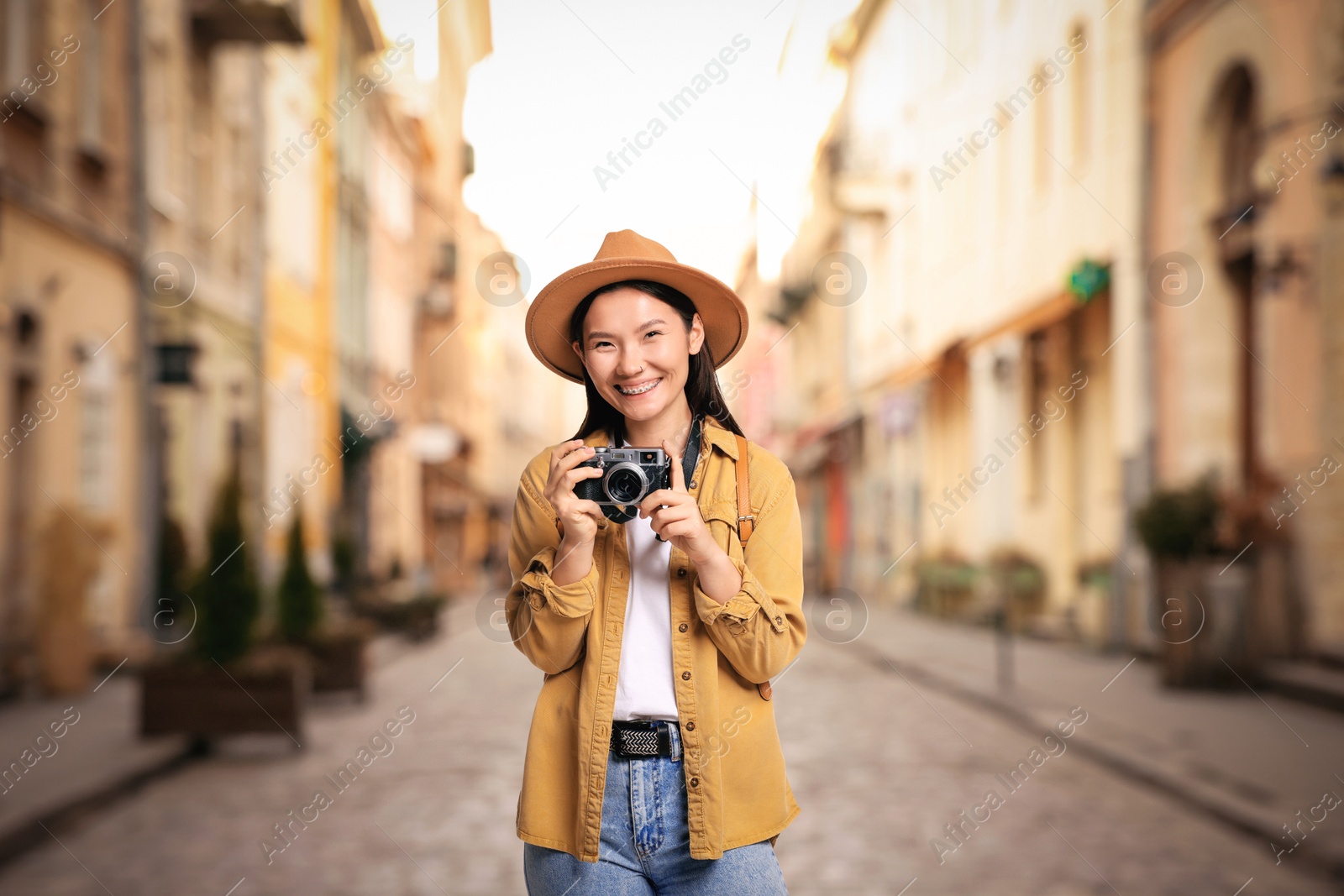 Happy tourist with camera on city street Image of Happy tourist with camera on city street