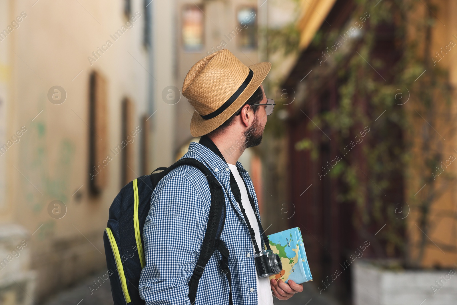 Tourist with camera, backpack and map on city street Image of Tourist with camera, backpack and map on city street