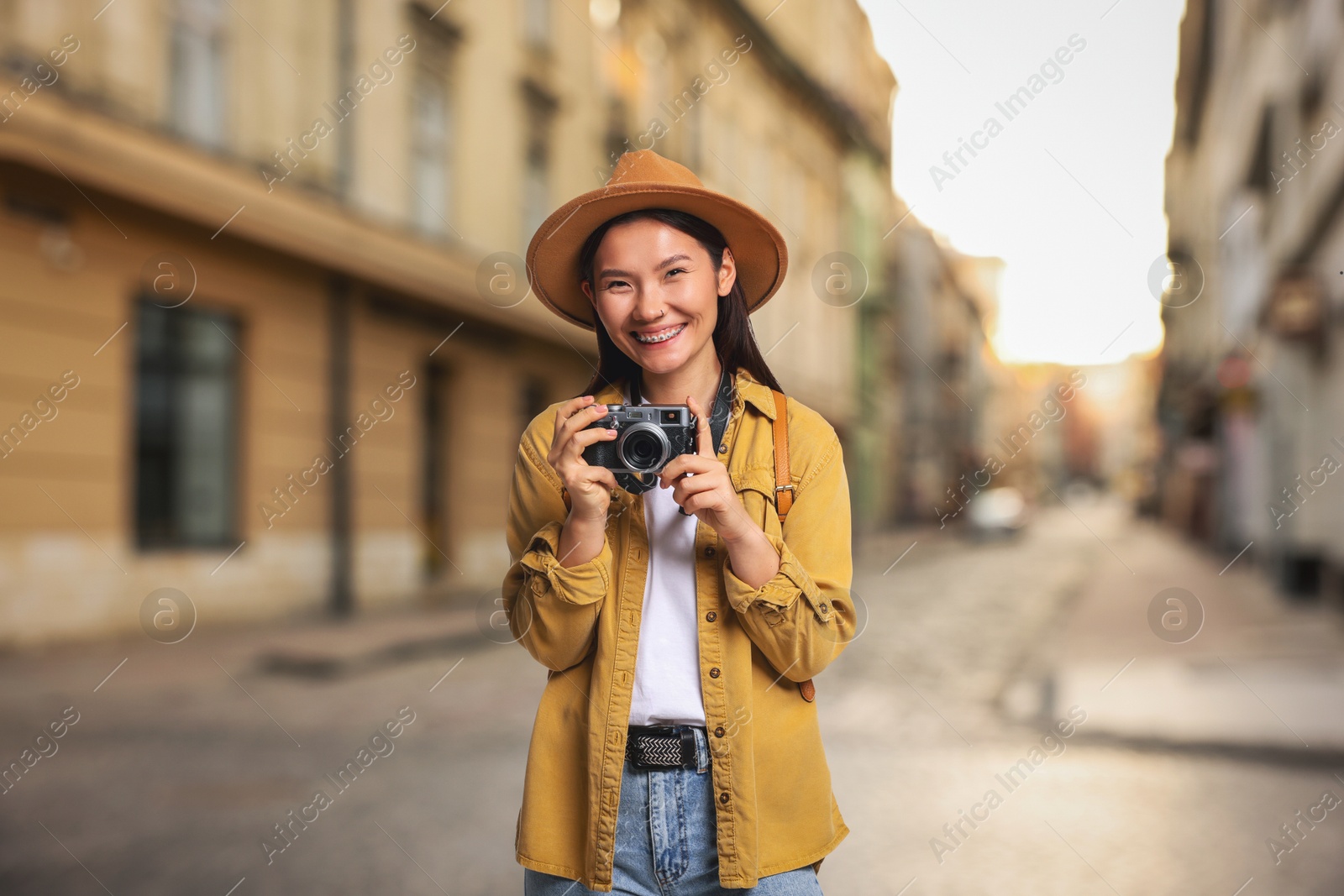 Happy tourist with camera on city street Image of Happy tourist with camera on city street