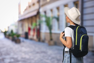 Image of Tourist with backpack on city street, back view. Space for text