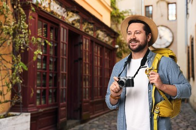Image of Tourist with backpack and camera on city street. Space for text