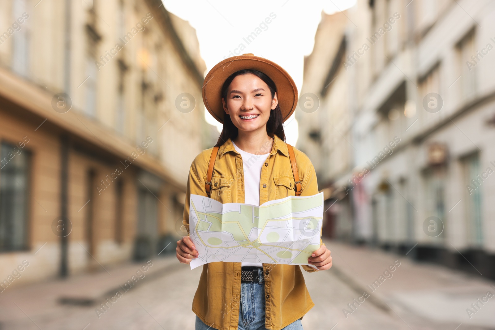 Happy tourist with map on city street Image of Happy tourist with map on city street