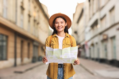 Image of Happy tourist with map on city street