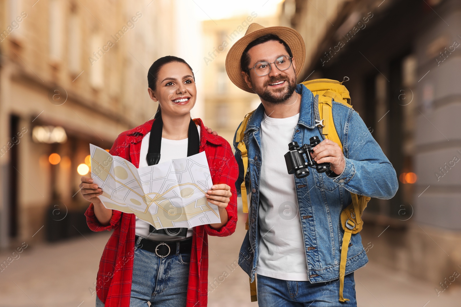Happy tourists with backpack, map and binoculars on city street Image of Happy tourists with backpack, map and binoculars on city street