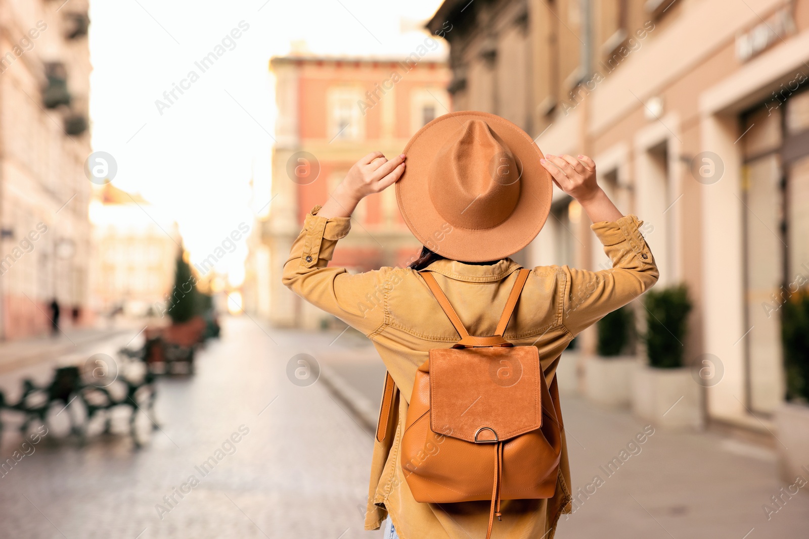 Tourist with backpack on city street, back view. Space for text Image of Tourist with backpack on city street, back view. Space for text