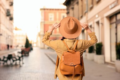 Image of Tourist with backpack on city street, back view. Space for text