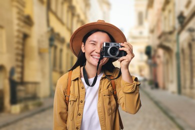 Image of Happy tourist taking photo on city street
